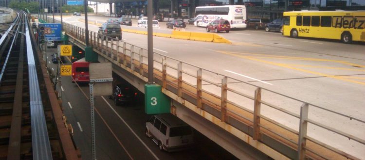 Busy airport roadway with multiple lanes, buses, and cars under a glass terminal canopy; signage shows Daily/Hourly parking and exits to city. GoChicagoLimo watermark on bottom.
