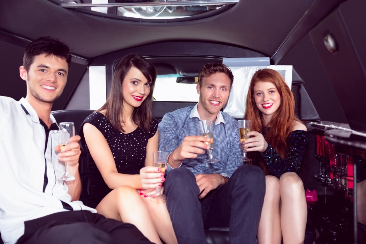 friends enjoying champagne ride in luxury limousine