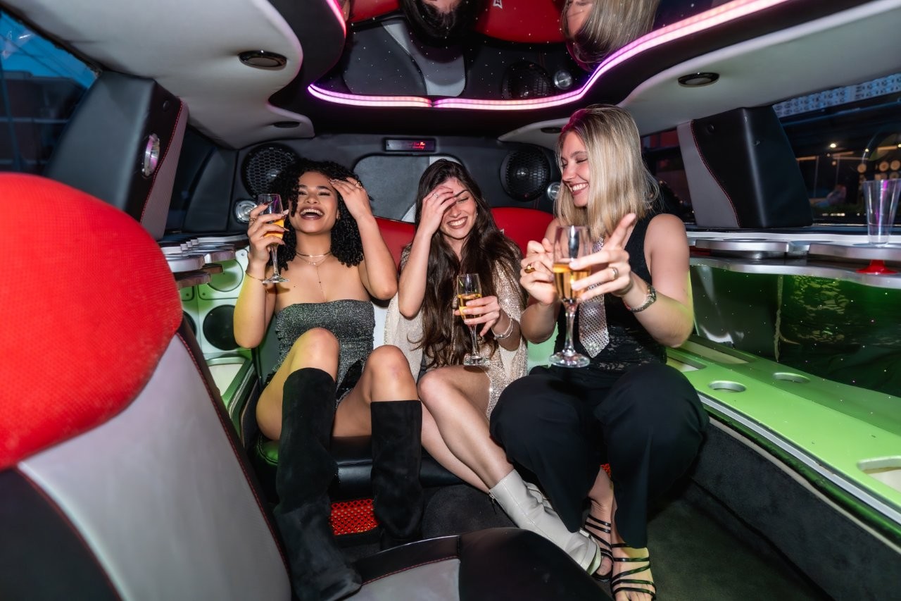 three joyful young women celebrating inside a luxury Chicago Limousine