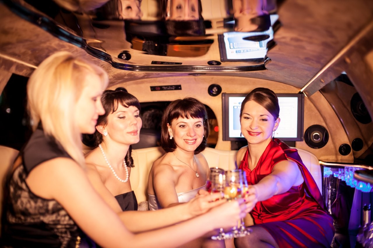 women toasting champagne in a limousine at night in Schaumburg